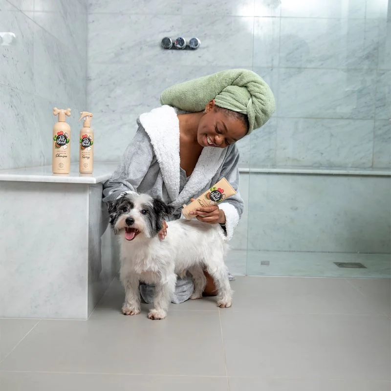 Garota cuidando de cão com produtos Pet Head numa casa de banho de mármore