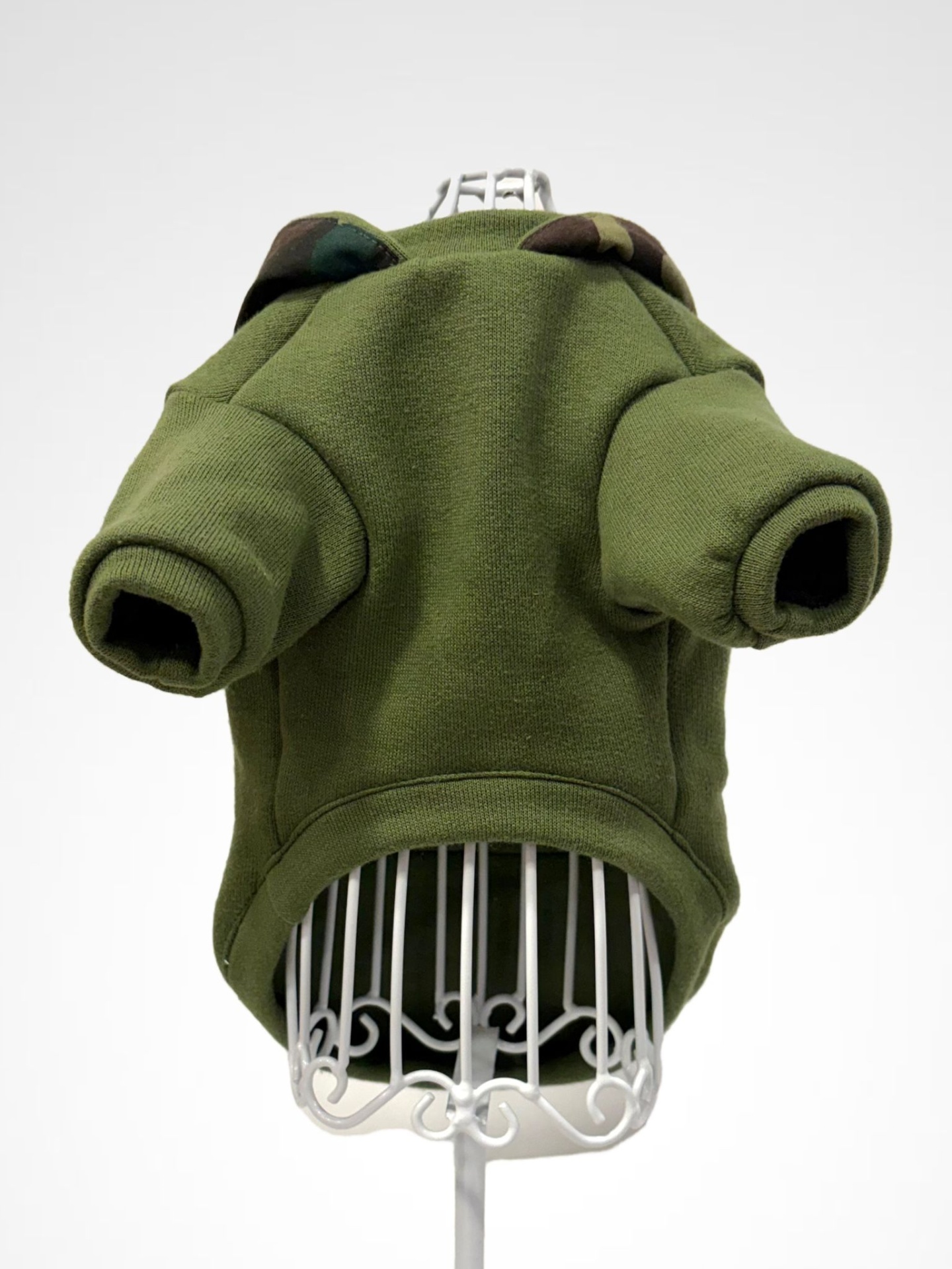 Casaco verde para cão com gola camuflada em suporte de arame branco