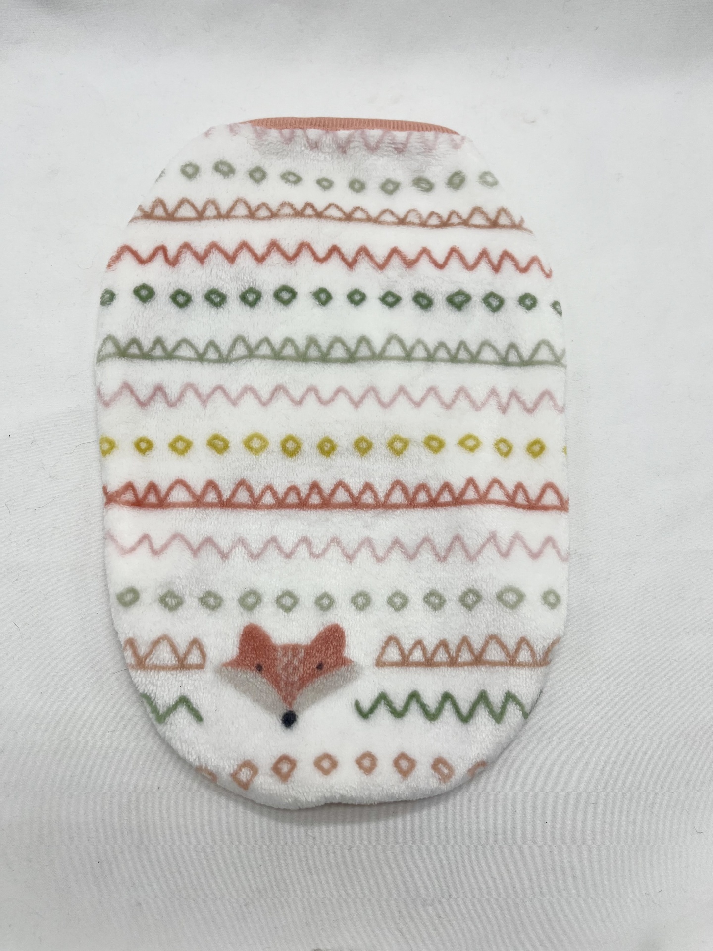 Almofada oval com padrão de zig-zags coloridos e rosto de raposa