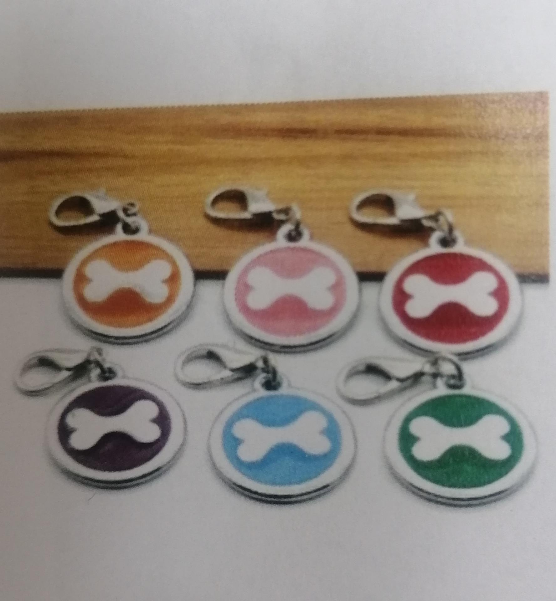 Seis porta-chaves redondos coloridos com padrão de osso branco e fecho metálico