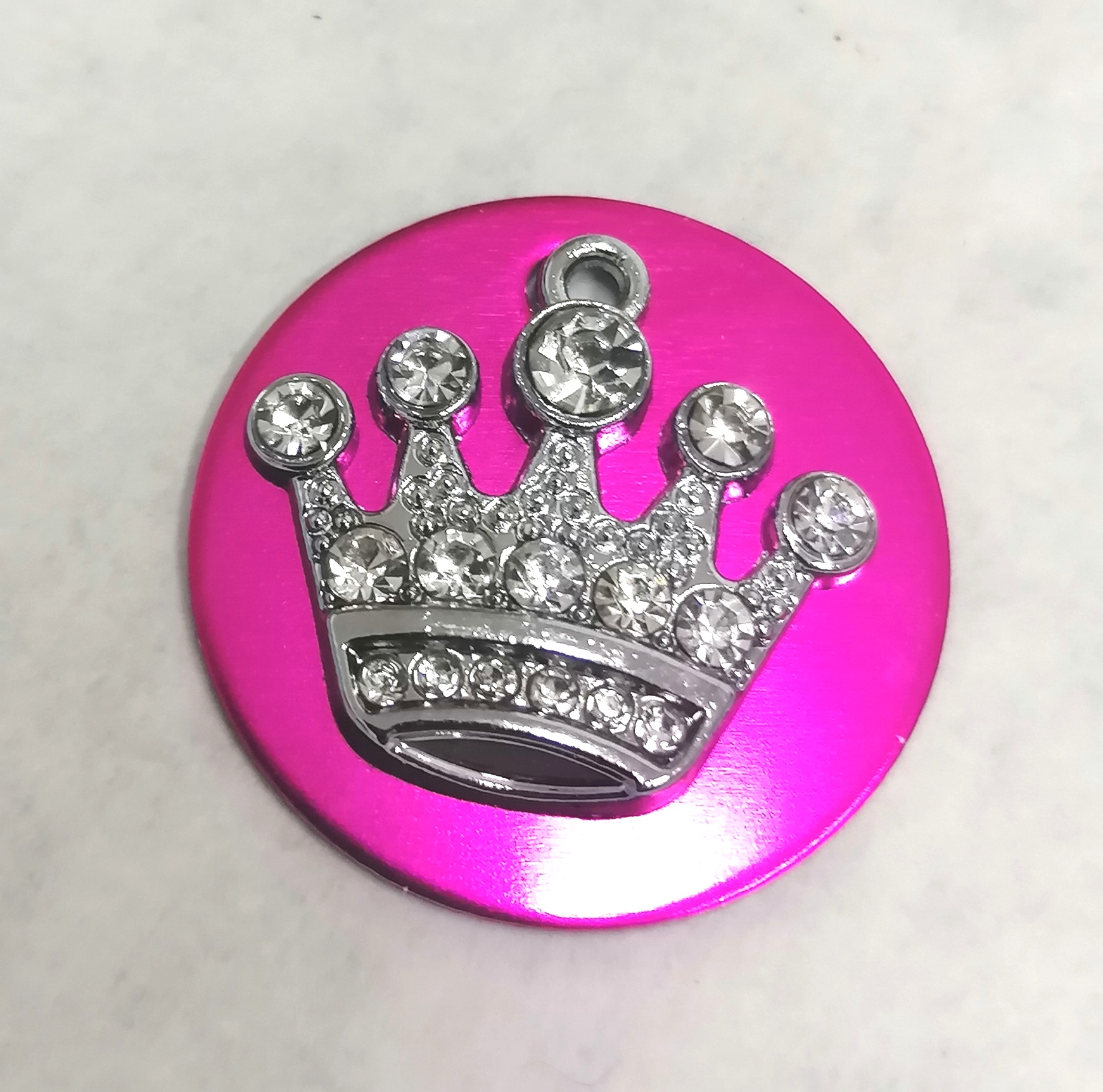 Botão redondo rosa com coroa prateada e pedras brilhantes