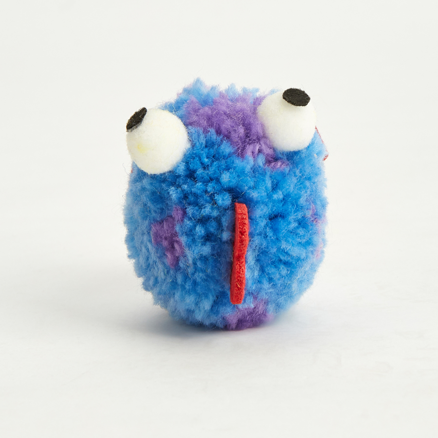 Brinquedo felpudo azul com olhos grandes e tira vermelha