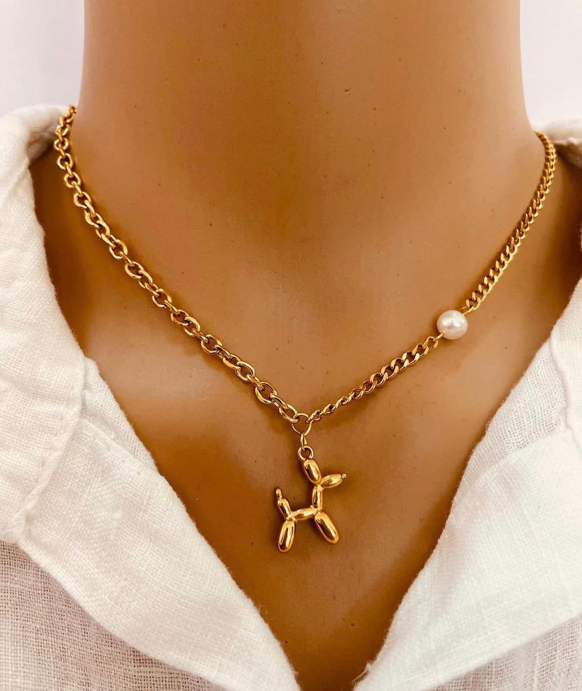 Colar dourado com pendente de cão e pérola branca