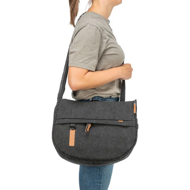Mala tiracolo cinzenta escura com detalhes castanhos a ser usada por pessoa