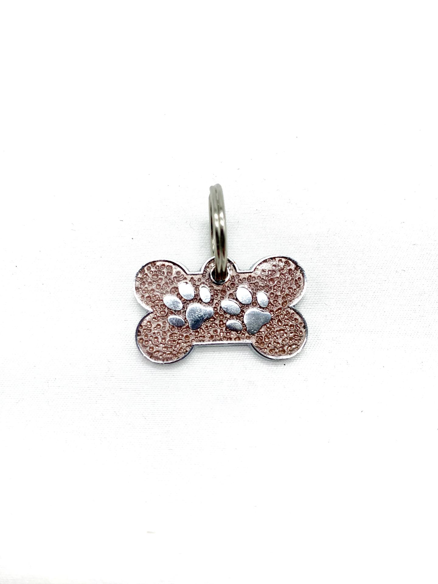 Pendente em forma de osso com marcas de patas