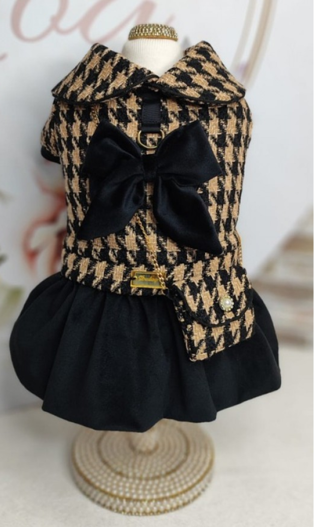 Vestido para cão pied-de-poule bege e preto com laço preto e saia preta num manequim decorado
