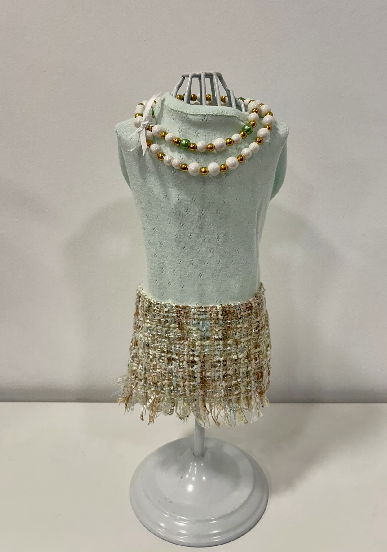 Colar de pérolas com contas coloridas no manequim com saia de tweed bege