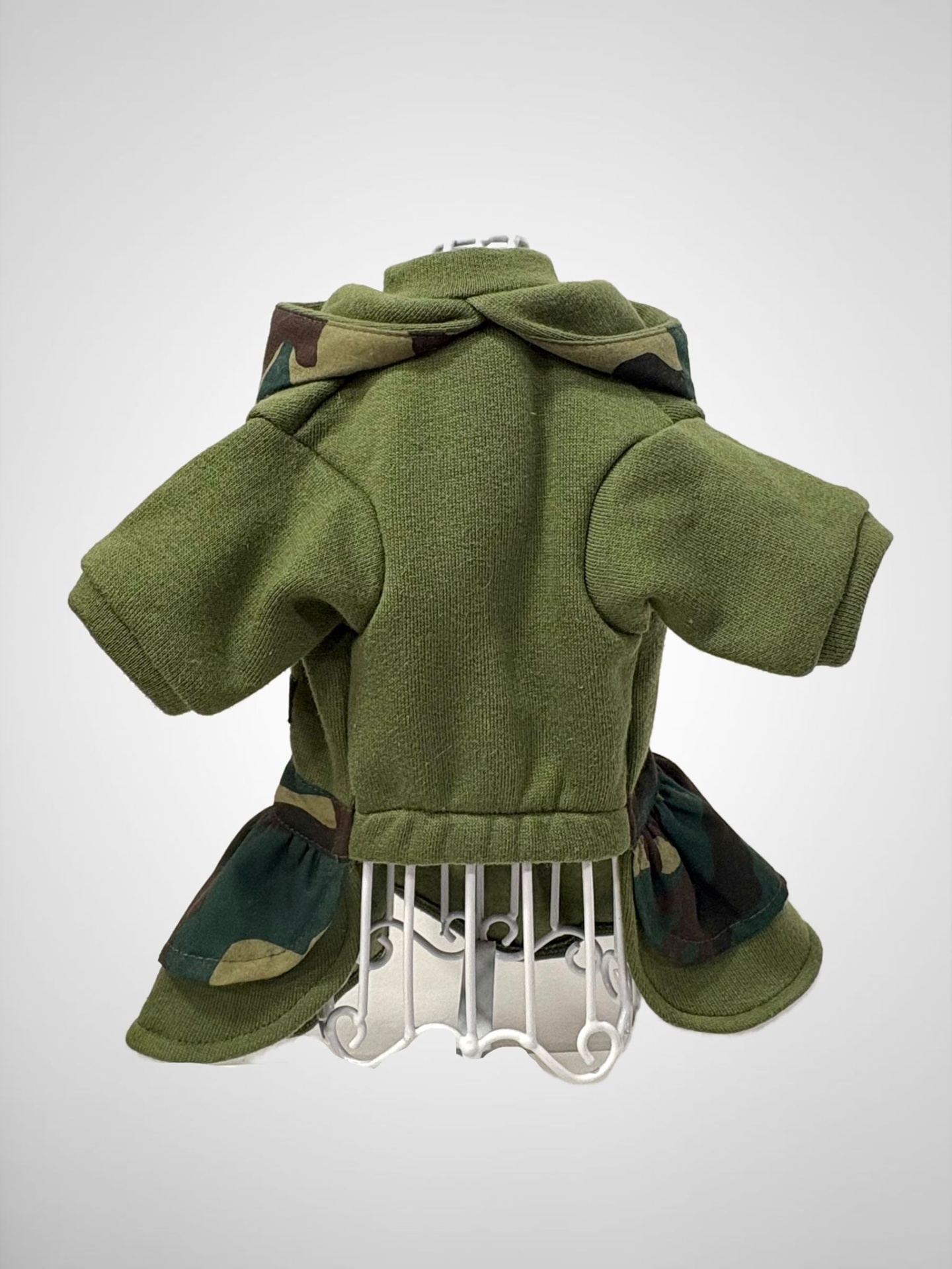 Casaco verde de lã com capuz e detalhes camuflados em maniquim branco