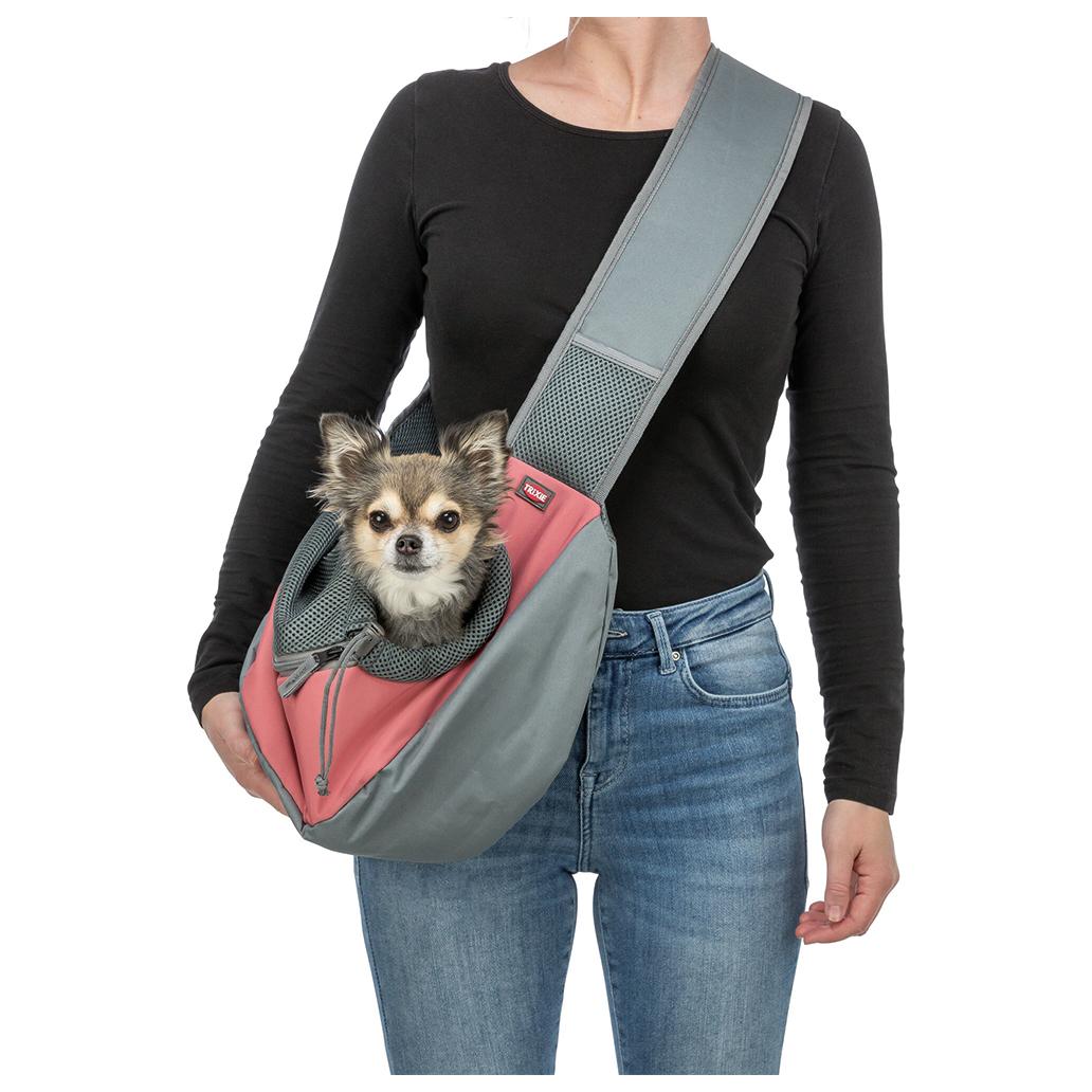 Mala de transporte cinza e rosa para cães com cão pequeno dentro usada ao ombro