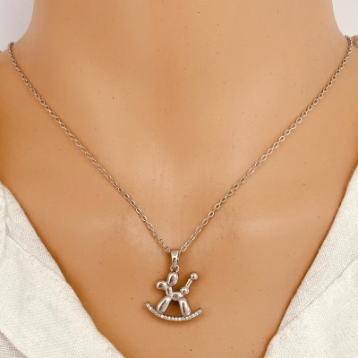 Colar com pendente de cavalinho de balanço prateado ao pescoço