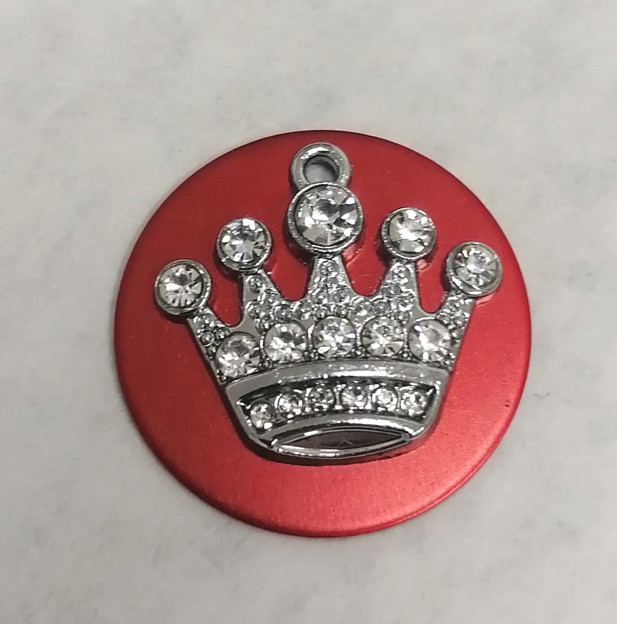 Pingente redondo vermelho com coroa prateada e cristais
