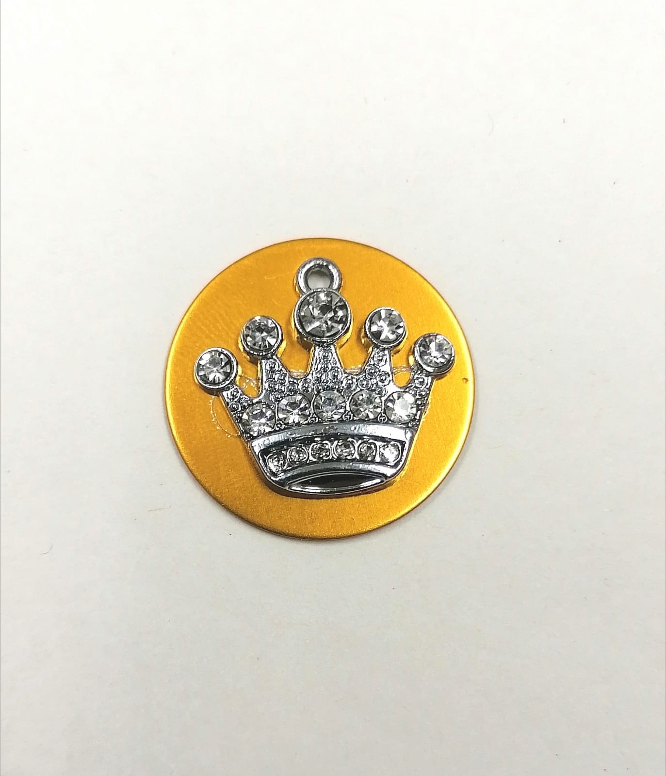 Botão dourado com coroa prateada e pedras brilhantes