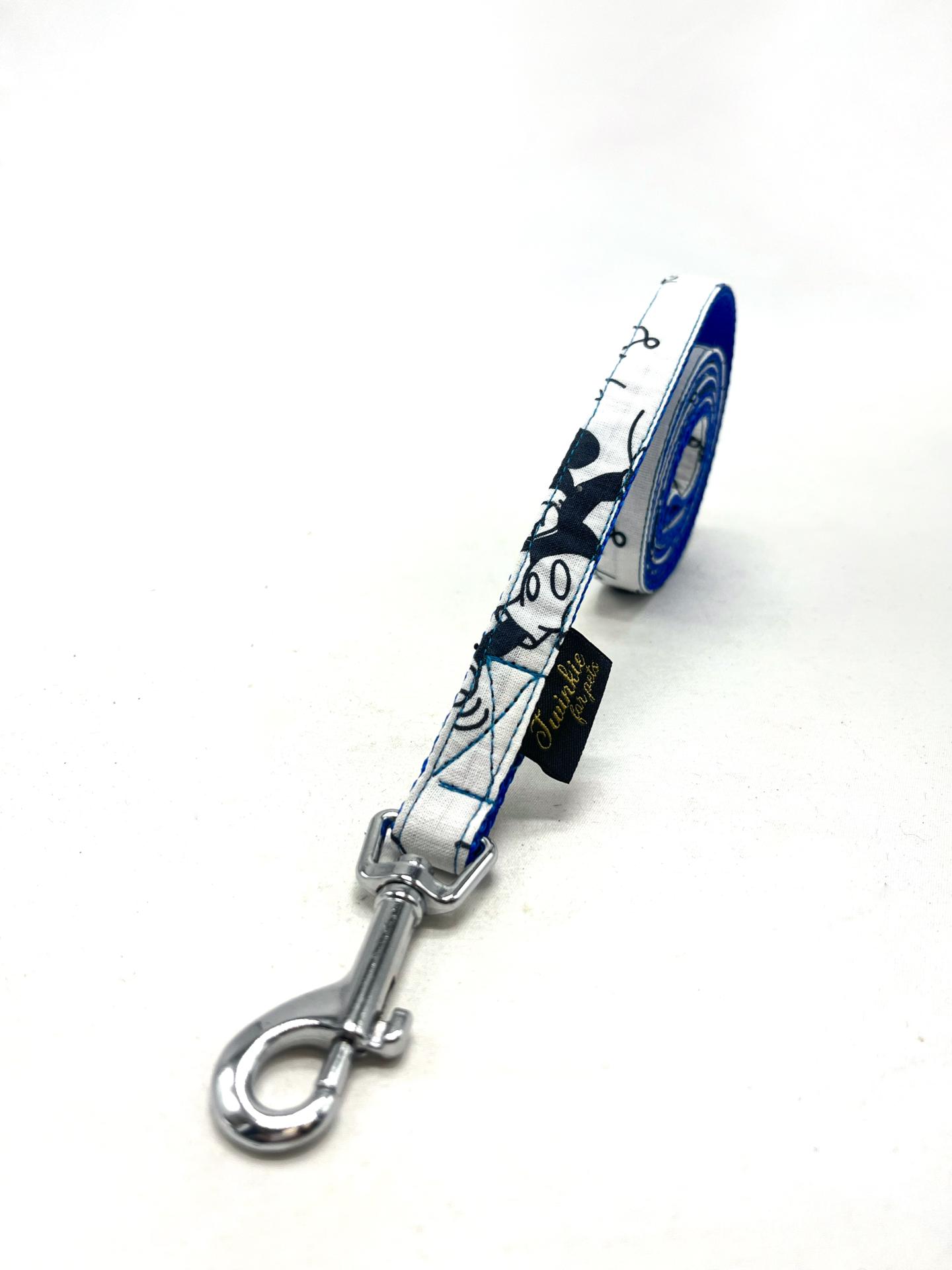 Trela de cão com padrão preto e branco, fecho metálico e etiqueta preta