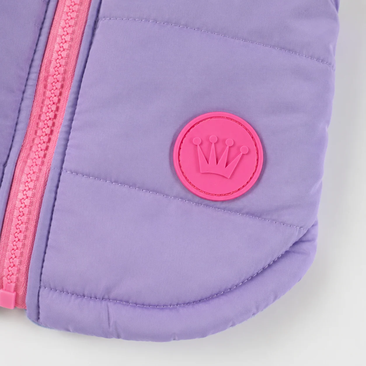 Casaco acolchoado lilás com fecho rosa e emblema de coroa cor-de-rosa