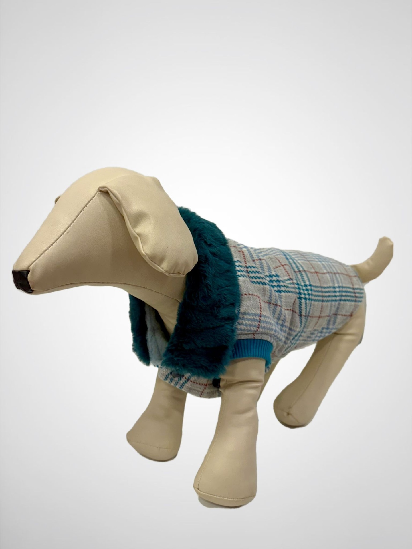 Figura de cão sintético com casaco xadrez cinza e gola azul escuro.