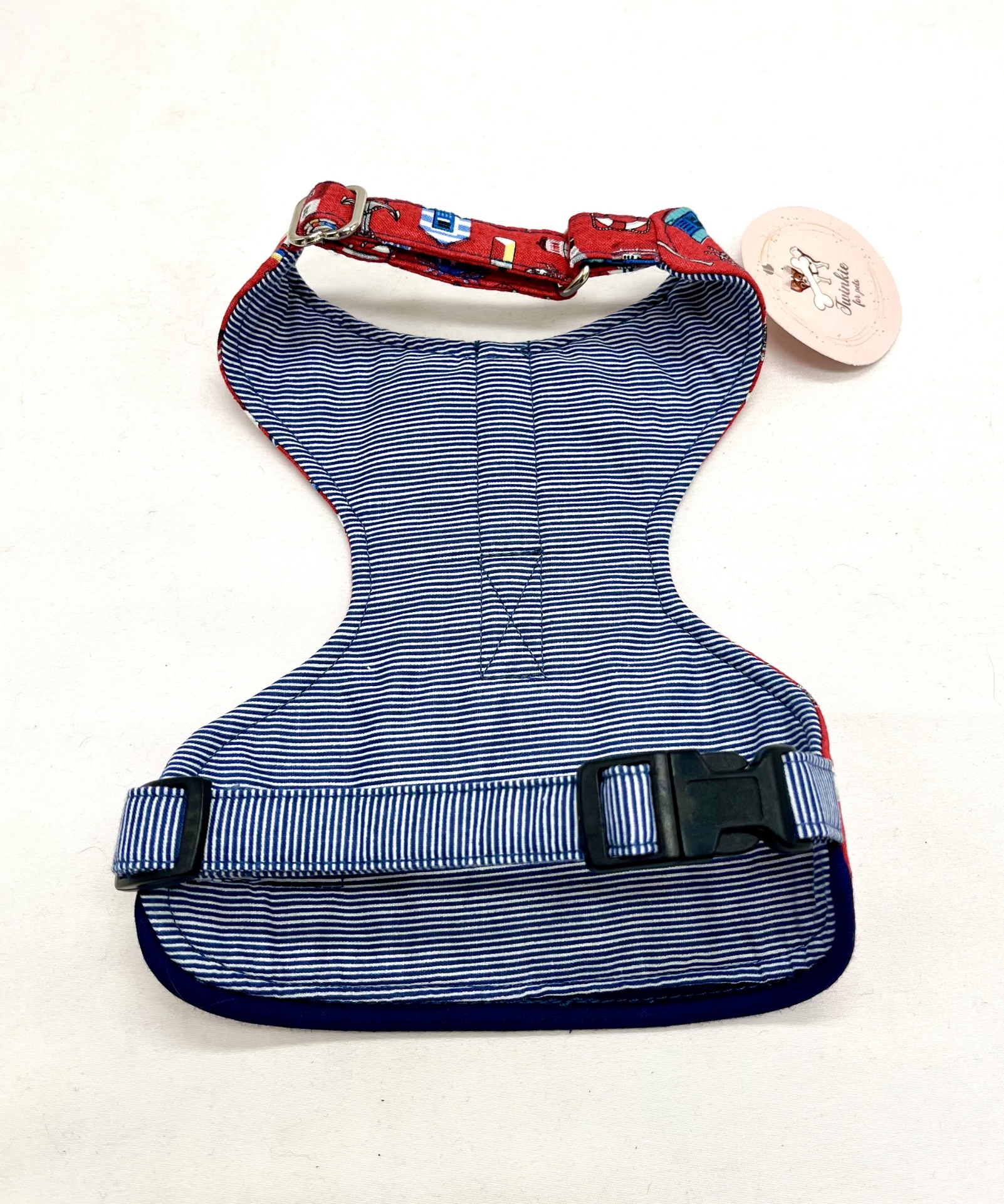 Colete peitoral azul às riscas com correias vermelhas e etiqueta redonda com imagem de cão