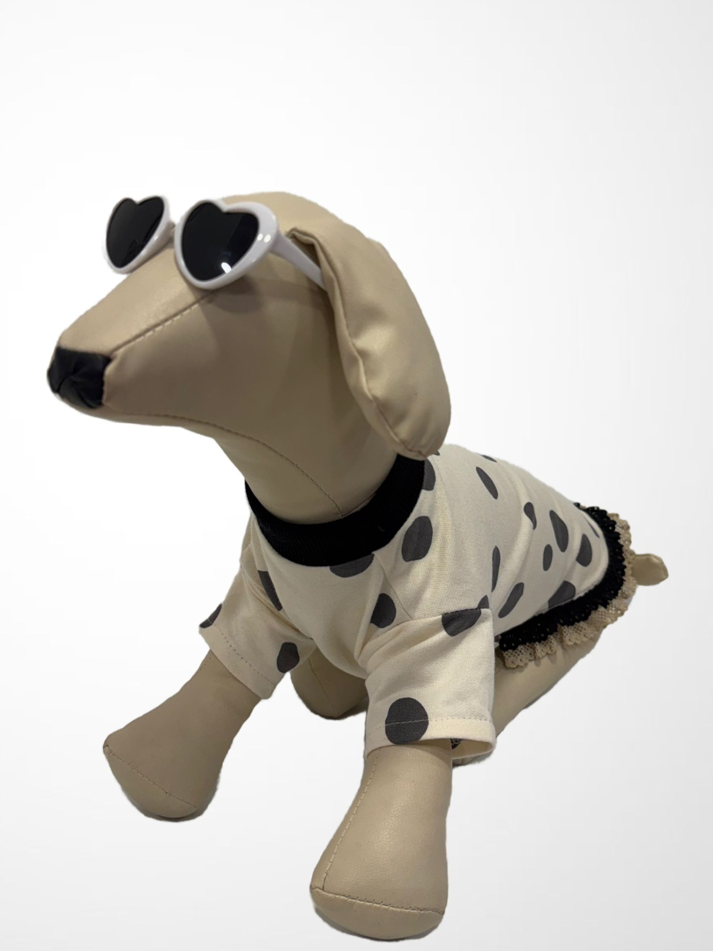 Mannequin cão sintético bege com roupa creme de bolinhas pretas e óculos de coração