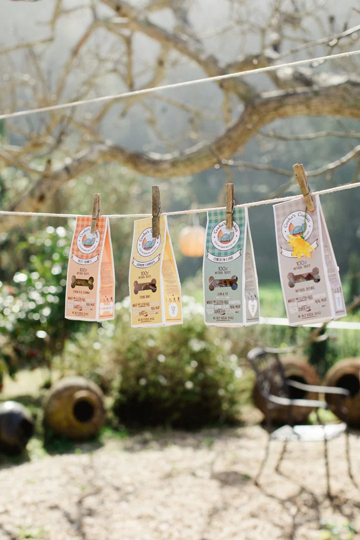 Embalagens de biscoitos para cães penduradas num estendal ao ar livre num jardim