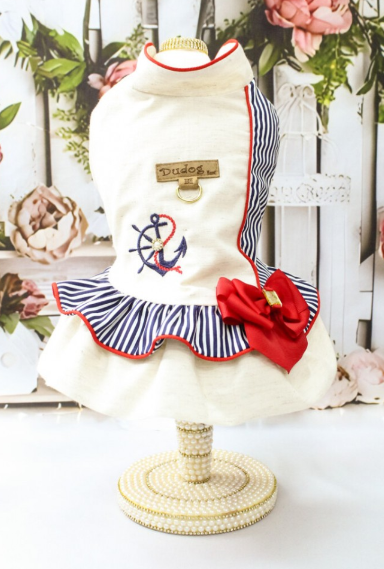 Vestido para cão branco com riscas azuis, bordado de âncora, laço vermelho, numa base perolada