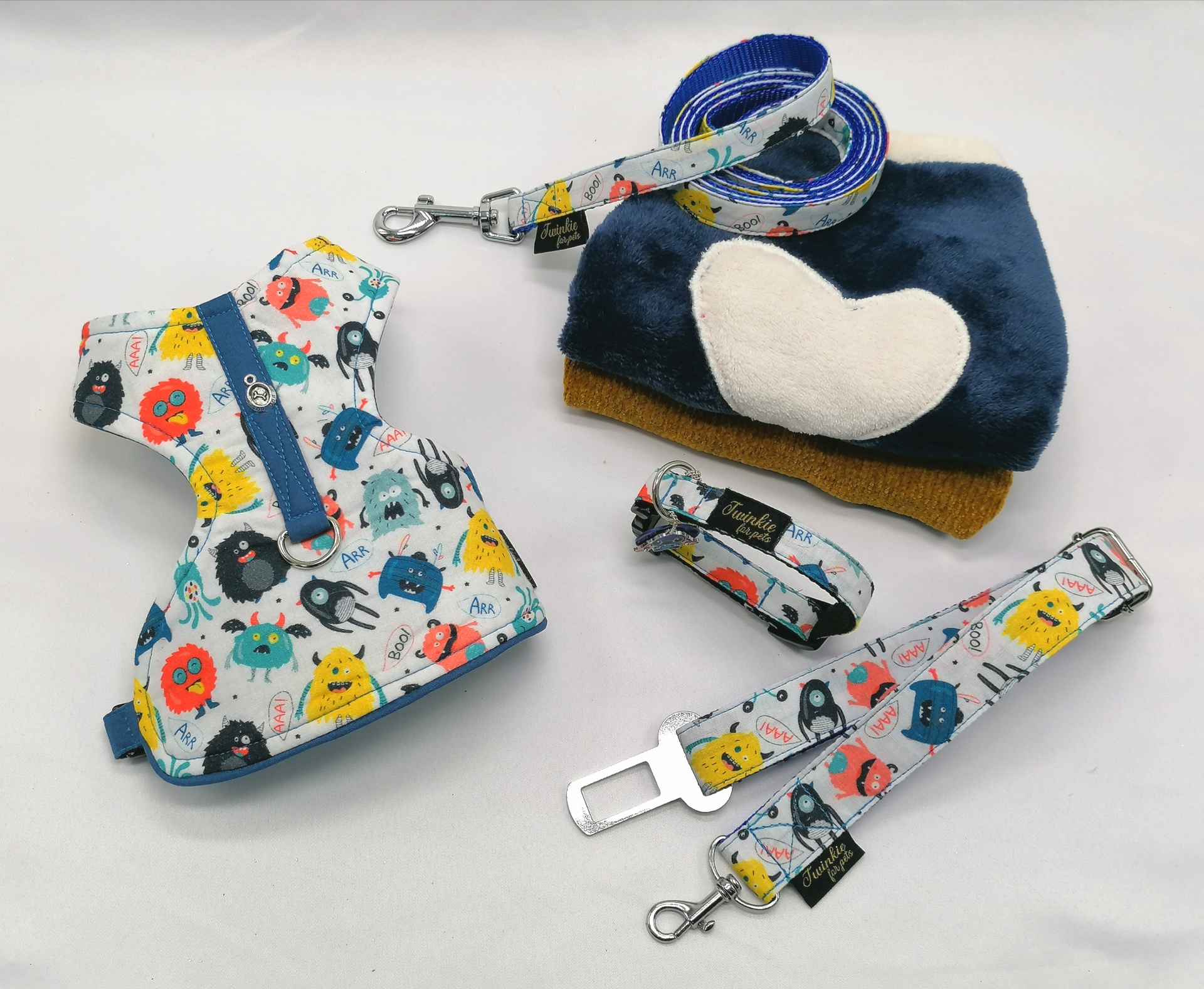 Conjunto de acessórios para cães com padrões de monstros coloridos e cama peluda azul com coração branco