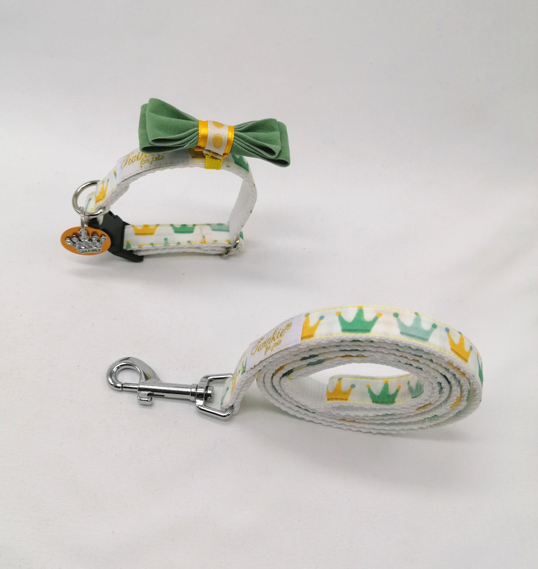 Coleira e trela branca com coroas coloridas e laço verde