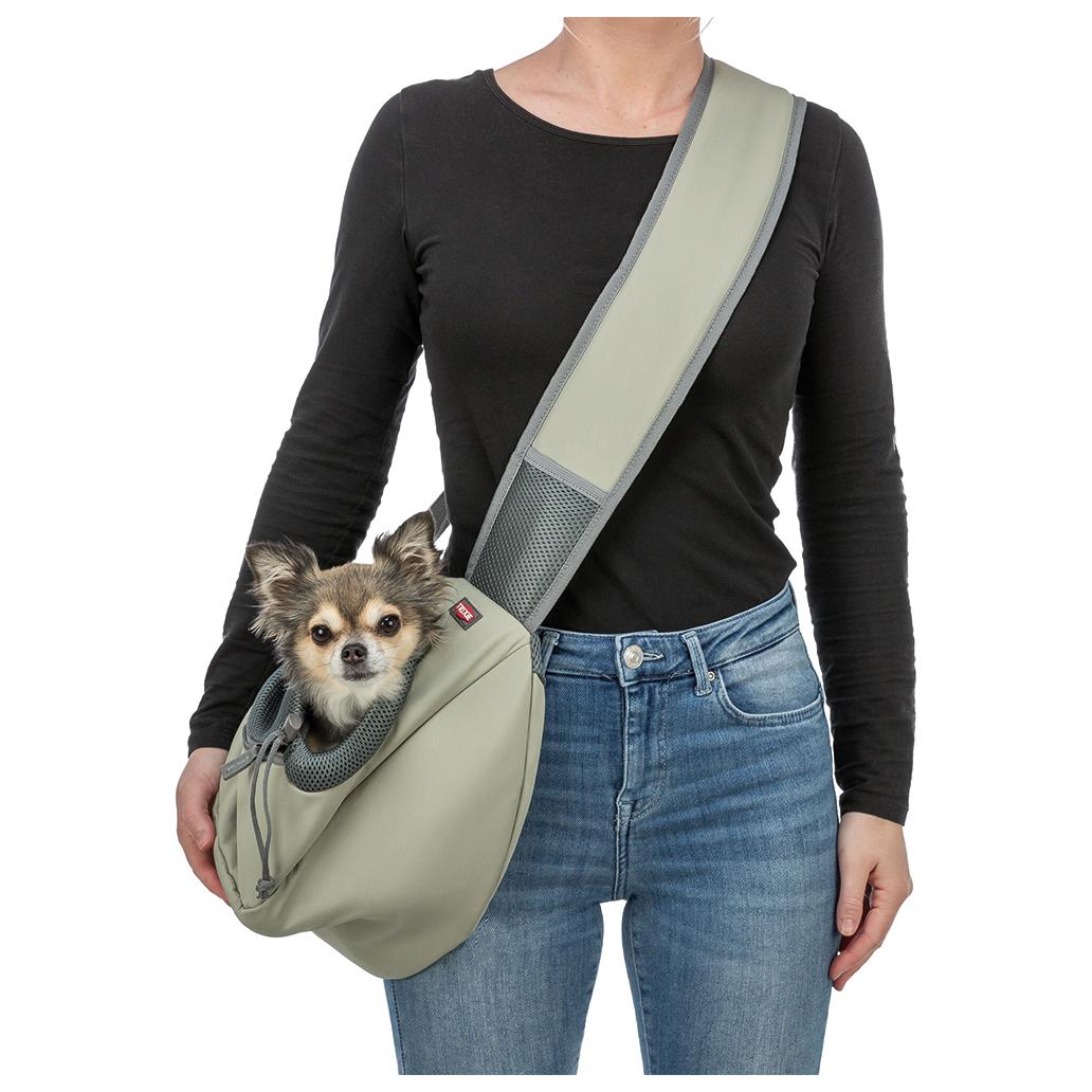 Saco transporte para cães cinza com cão pequeno, usado por pessoa com camisa preta e jeans