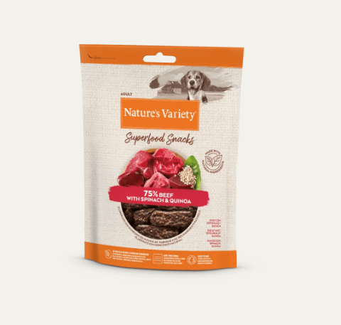Pacote branco e laranja de snacks para cães Nature's Variety com imagem de carne, espinafres e quinoa.