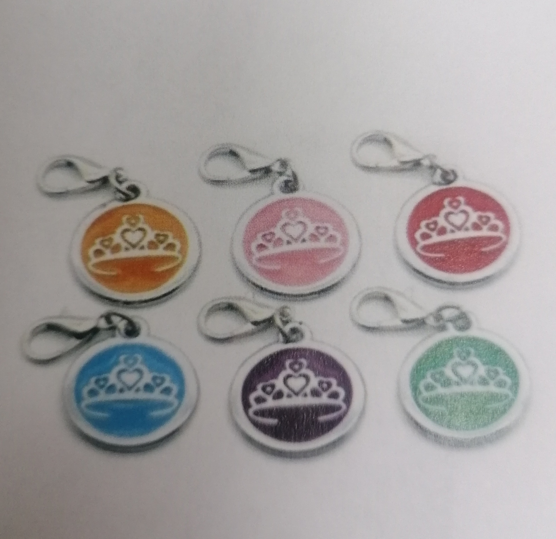 Conjunto de seis porta-chaves redondos com desenho de coroa e fundo colorido