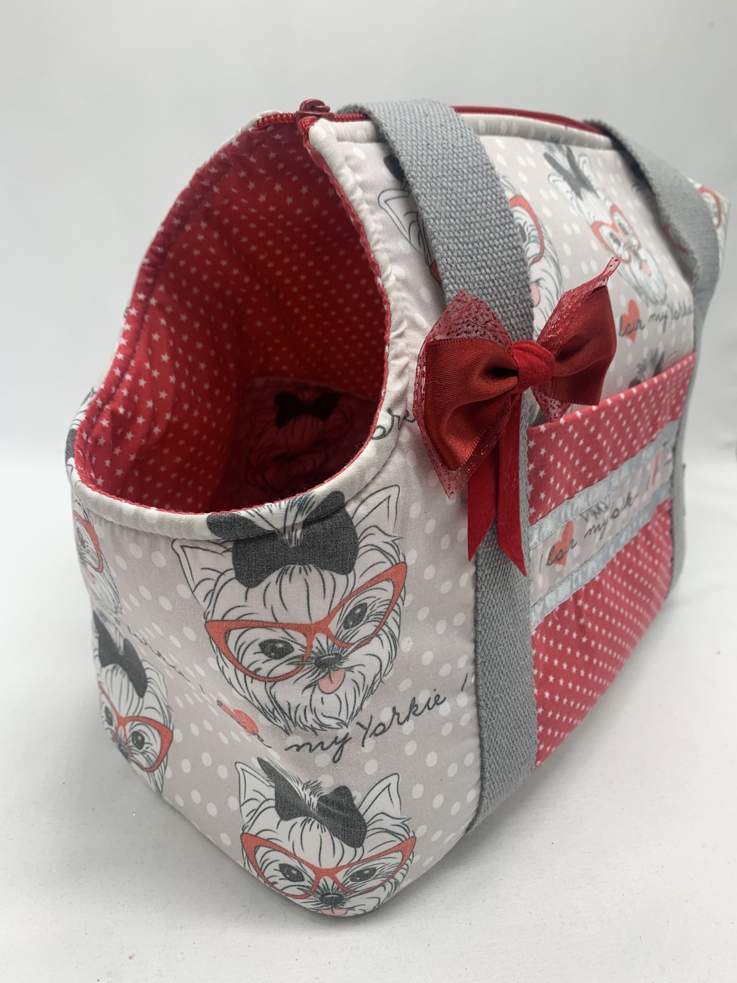 Bolsa estampada com cães Yorkshire em tecido cinza com bolinhas, alças cinzentas e laço vermelho.