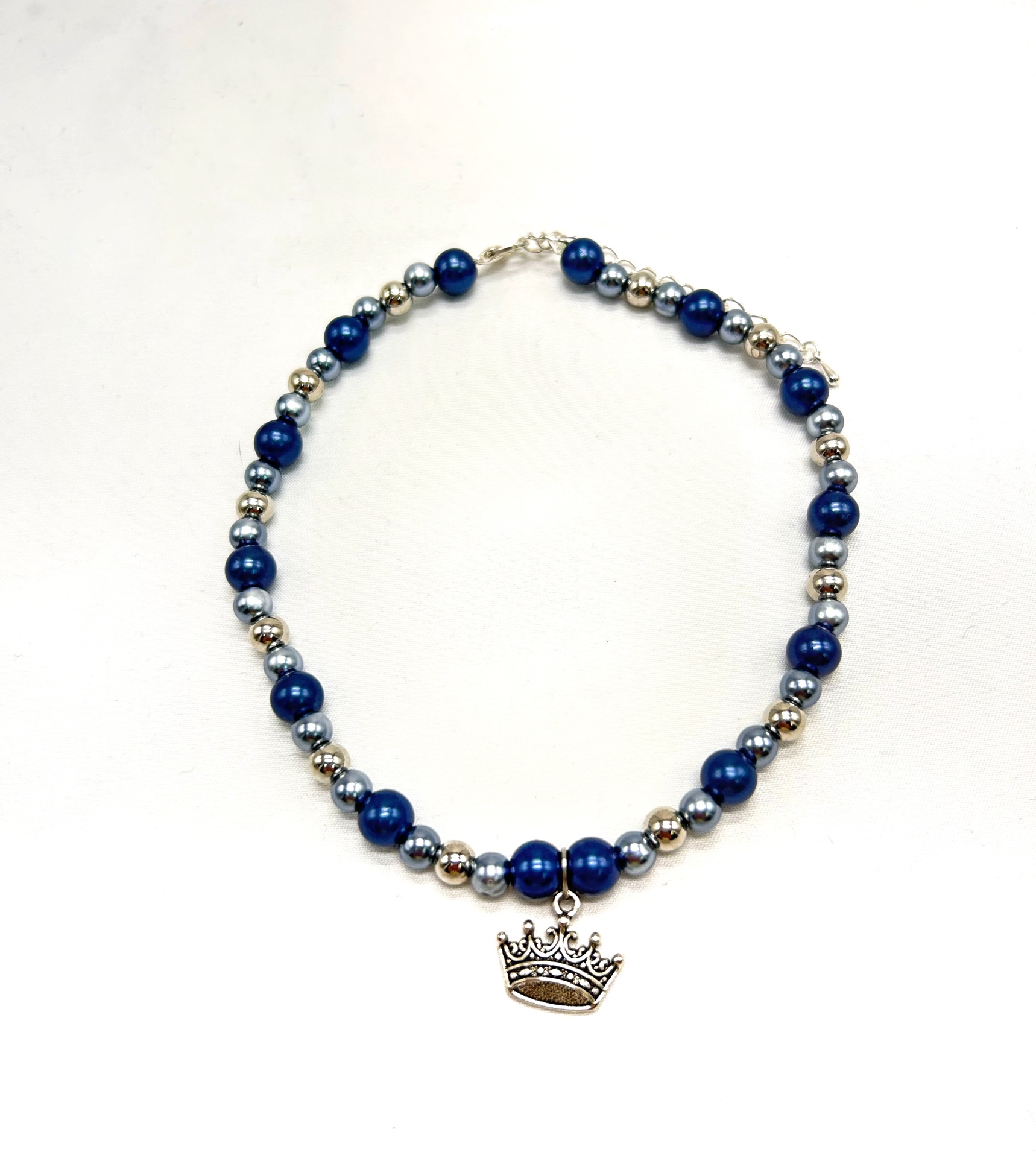 Colar com contas azuis e prateadas e pendente de coroa