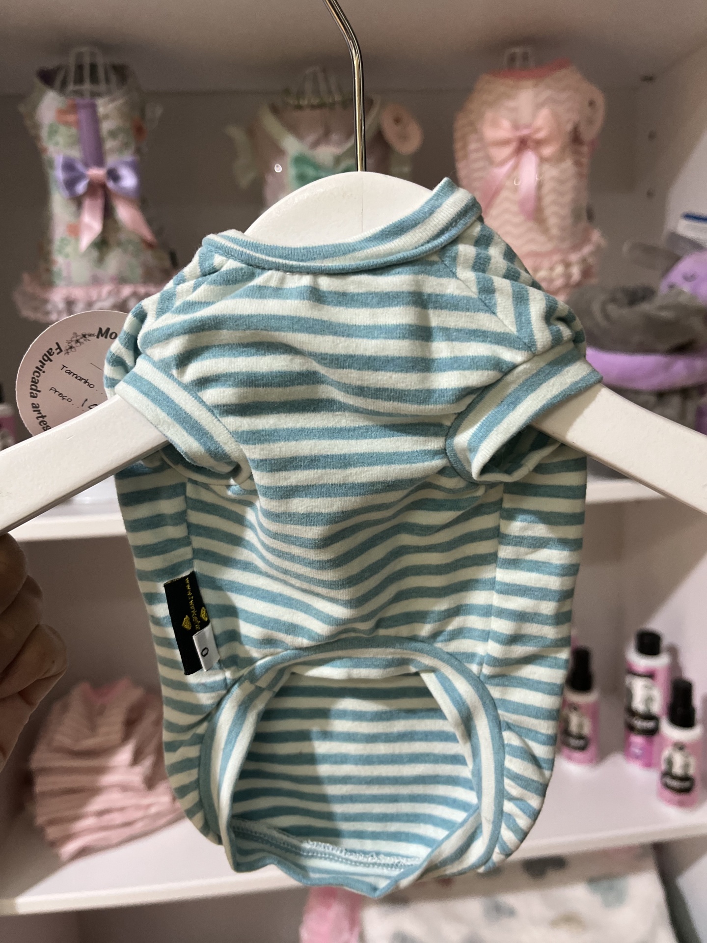 Camisola azul e branca de riscas para cão pendurada em cabide