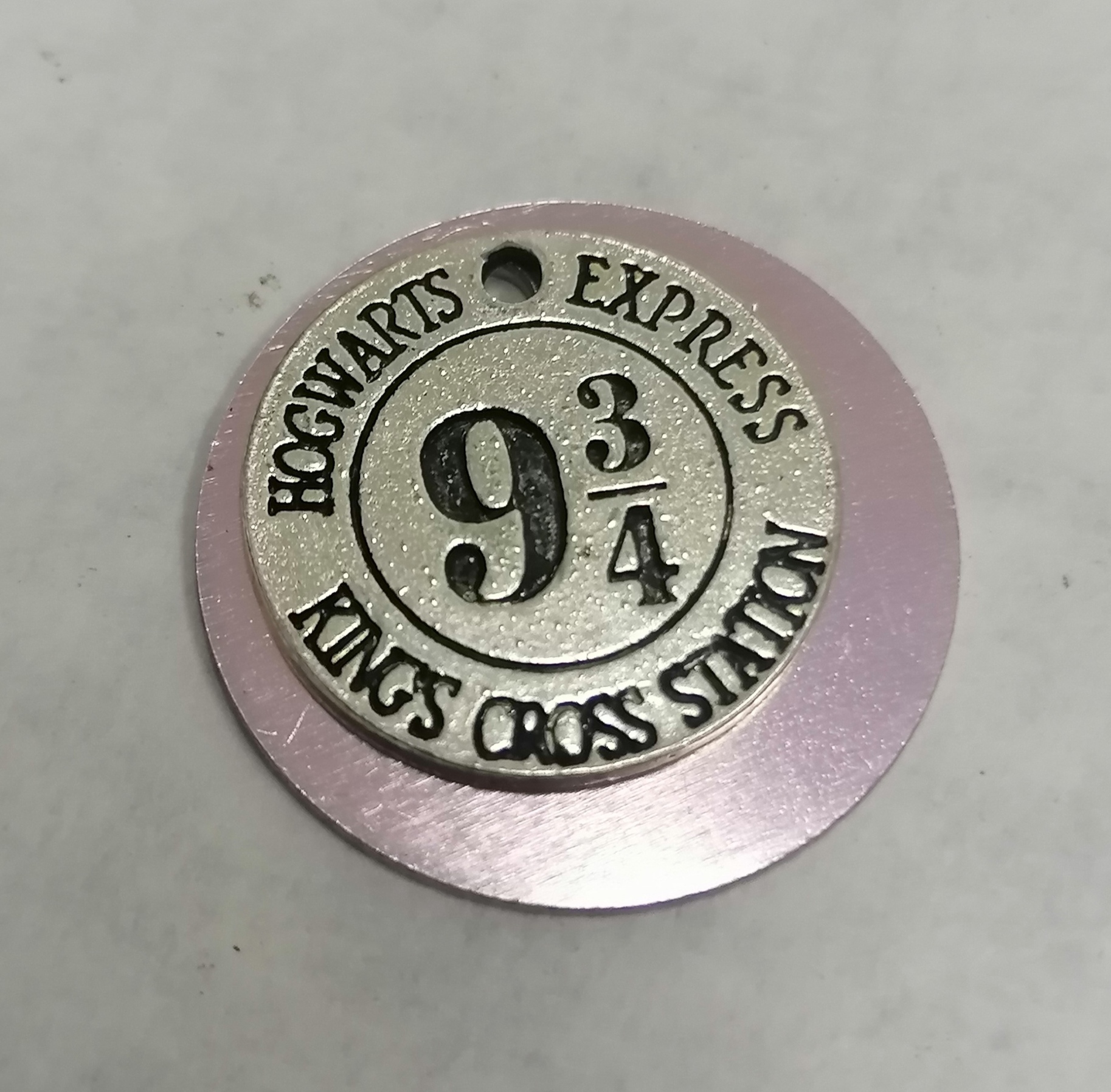 Disco metálico redondo com inscrição Hogwarts Express 9 3/4 Kings Cross Station
