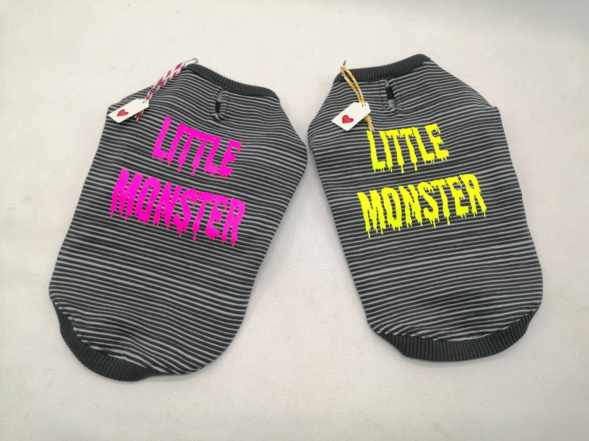 Dois casacos para cães riscado cinza e preto com texto LITTLE MONSTER em rosa e amarelo