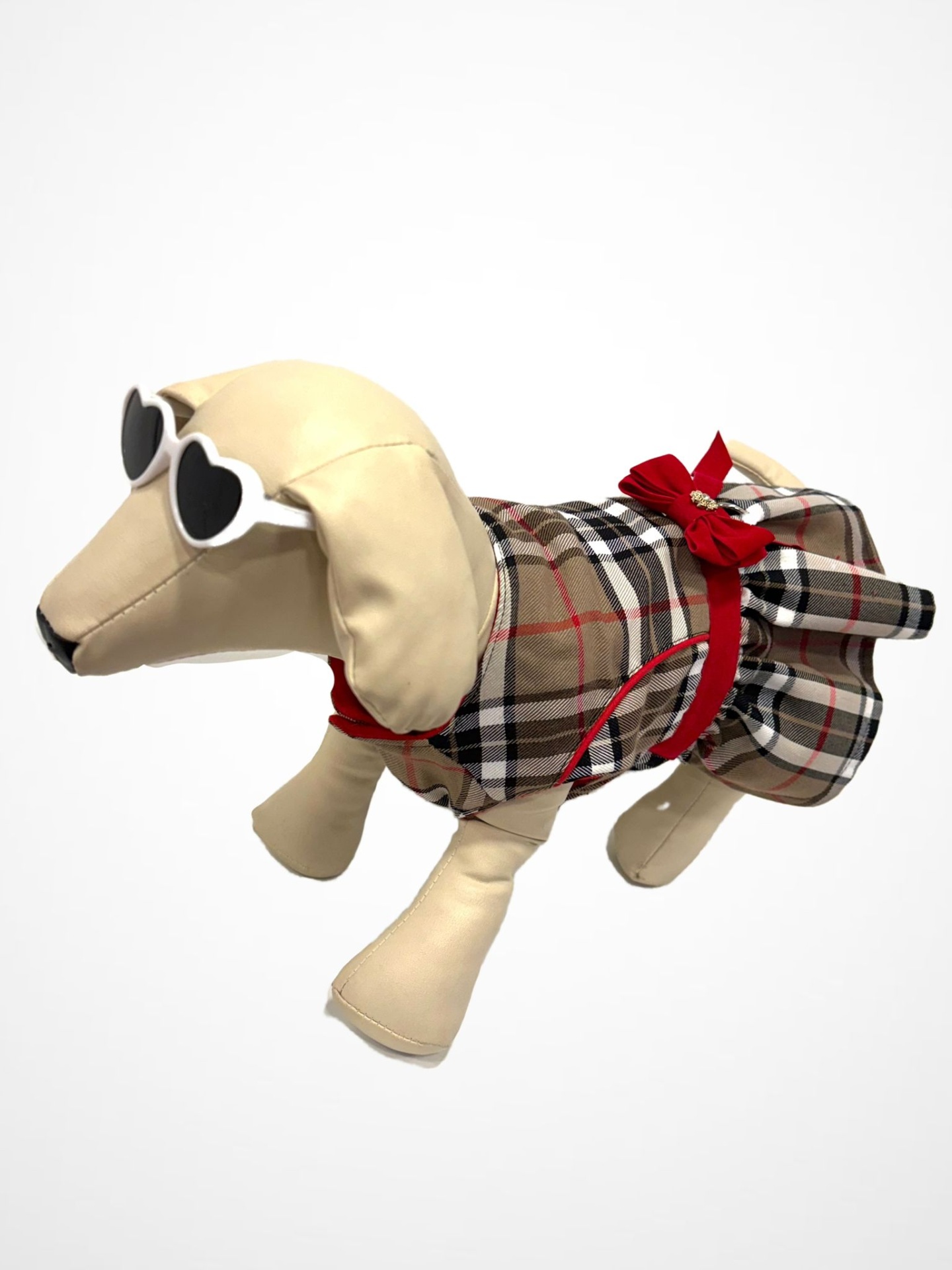 Boneco de cão em material bege com roupa xadrez castanha e óculos de sol coração