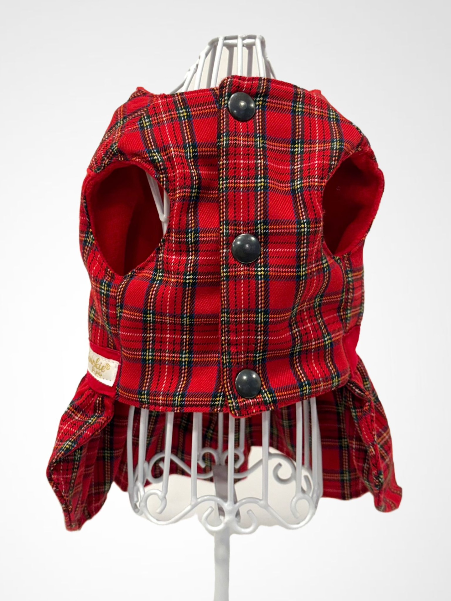 Colete xadrez vermelho para animais com botões pretos em manequim branco.