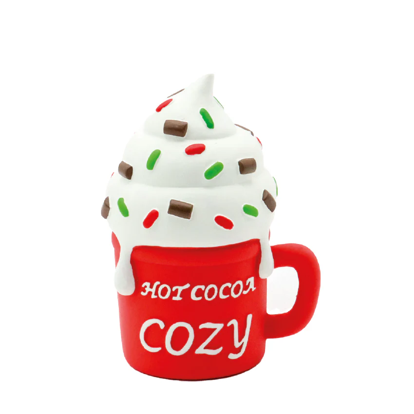 Caneca vermelha com chantili e confeitos coloridos e texto HOT COCOA COZY