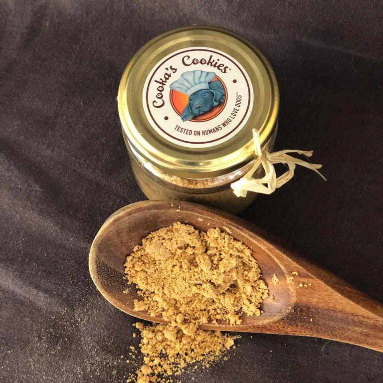 Frasco com pó castanho claro ao lado de colher de madeira