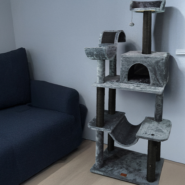 Arranhador para gatos cinza com vários níveis junto a sofá azul escuro
