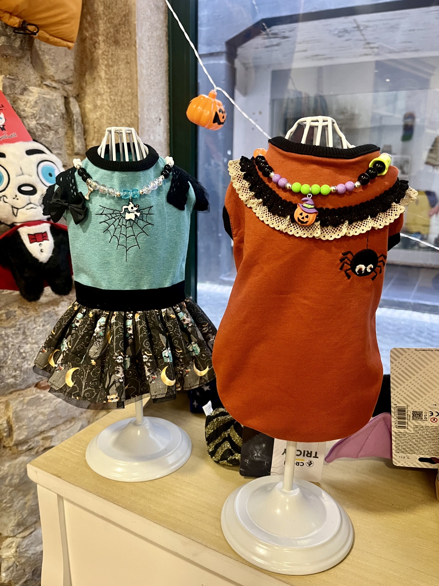 Vestidos Halloween para animais com detalhes nas cores azul e laranja, colares com contas coloridas e acessórios temáticos