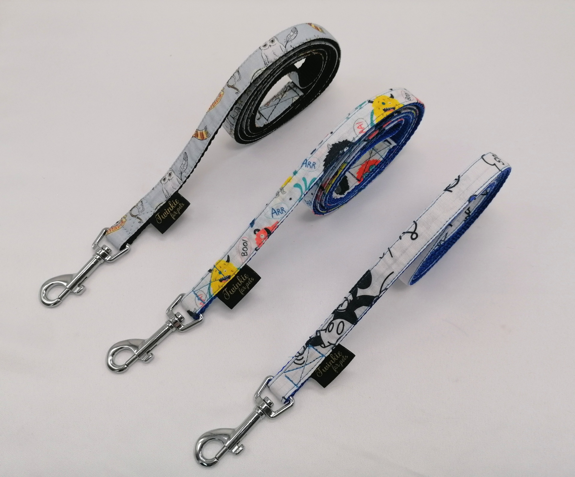 Três trelas para cães coloridas com fechos metálicos.