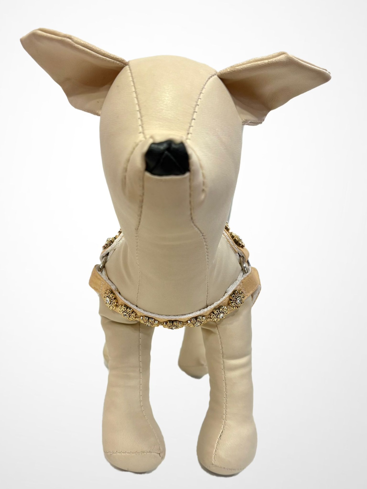 Estatueta de cachorro bege com coleira decorada em fundo branco