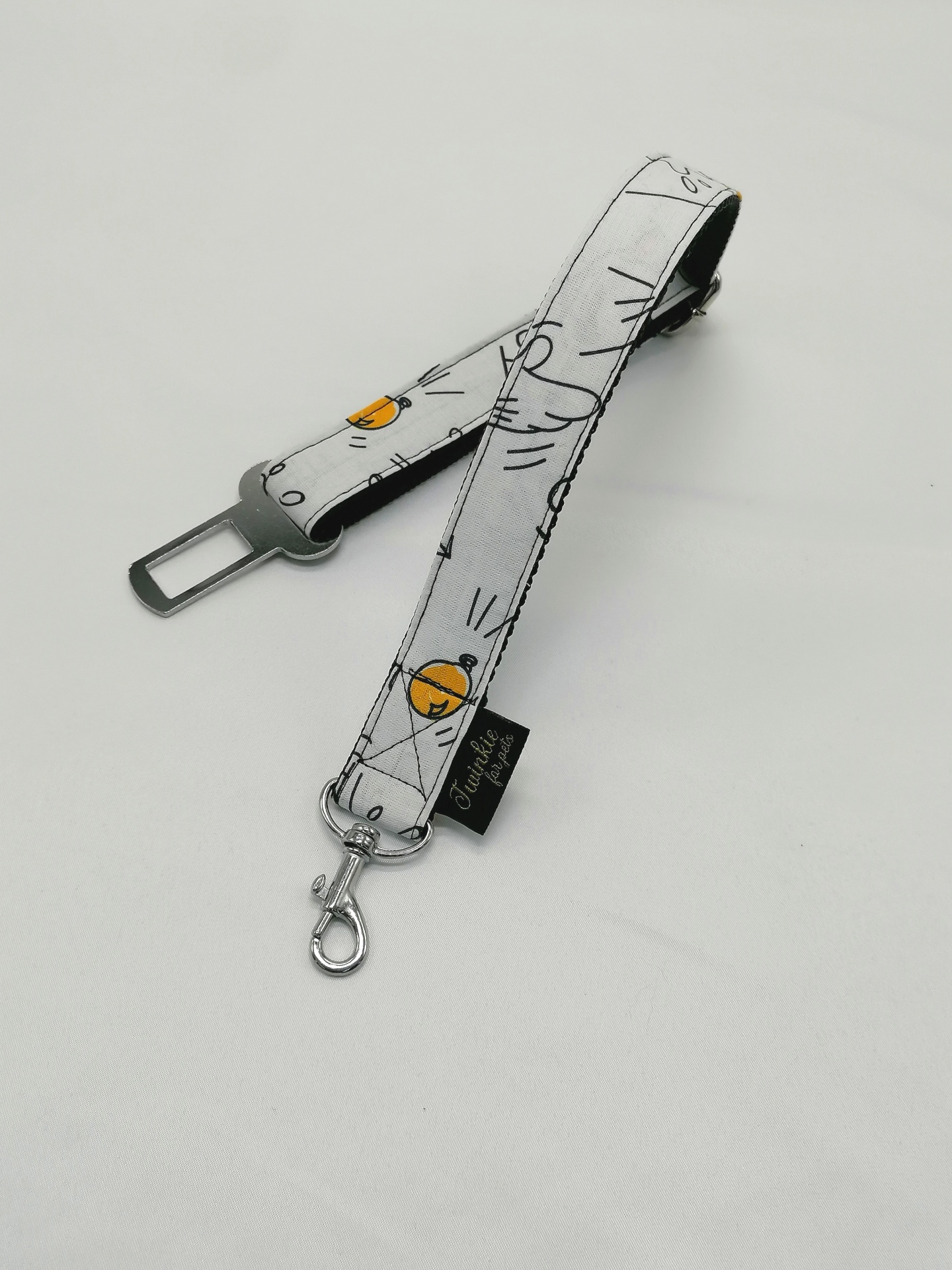 Cinto de segurança para animais branco com padrões pretos e detalhes laranja