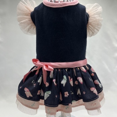 Vestido azul escuro com gola rosa, mangas de tule creme e saia com padrão de borboletas e flores