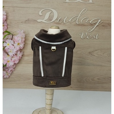 Colete castanho para cão com detalhes brancos e argola dourada num suporte decorado com pérolas