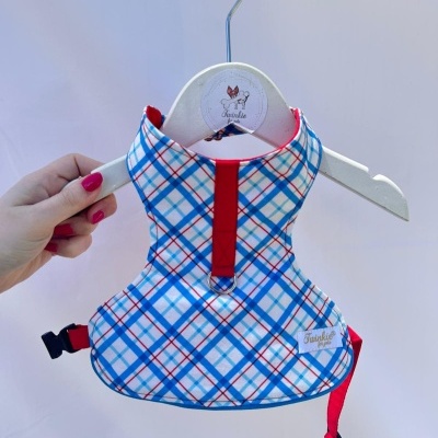 Peitoral de cão xadrez azul, vermelho e branco pendurado em cabide branco