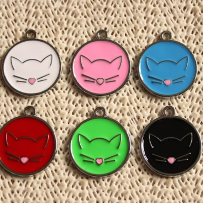 Seis medalhas redondas coloridas com desenho de gato sobre tecido bege