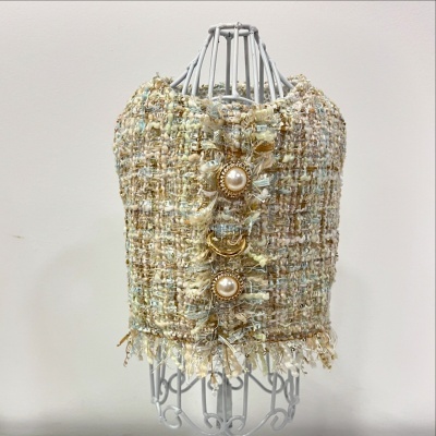 Top tweed bege com botões dourados e pérolas em manequim branco