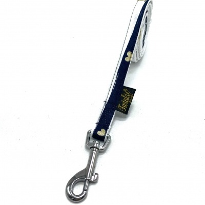 Trela para cão azul escuro com corações dourados, mosquetão metálico prateado e etiqueta preta.