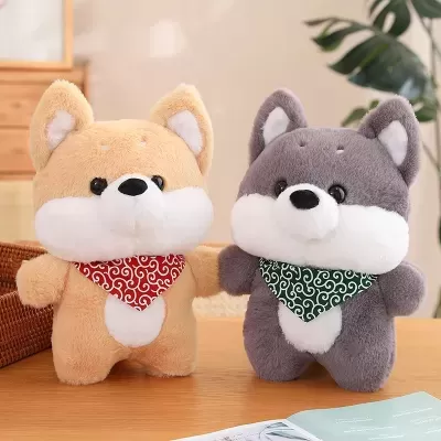Dois peluches de cães, um bege e outro cinzento, com cachecóis coloridos, sobre uma mesa de madeira.