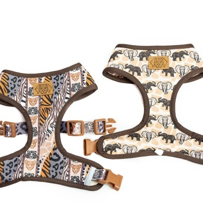 Dois peitorais de cão com padrões de animais em tecidos macios, com fechos ajustáveis.